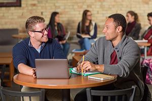 two students at table talking